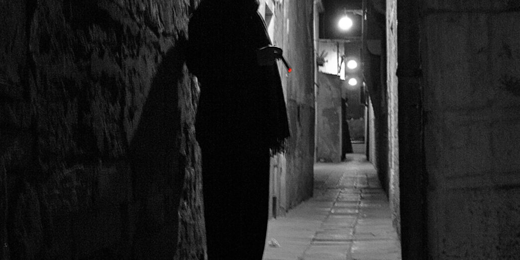 a man standing in a dark alley