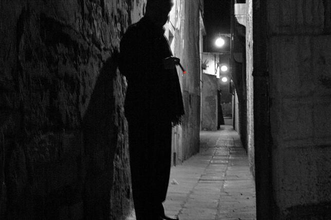 a man standing in a dark alley