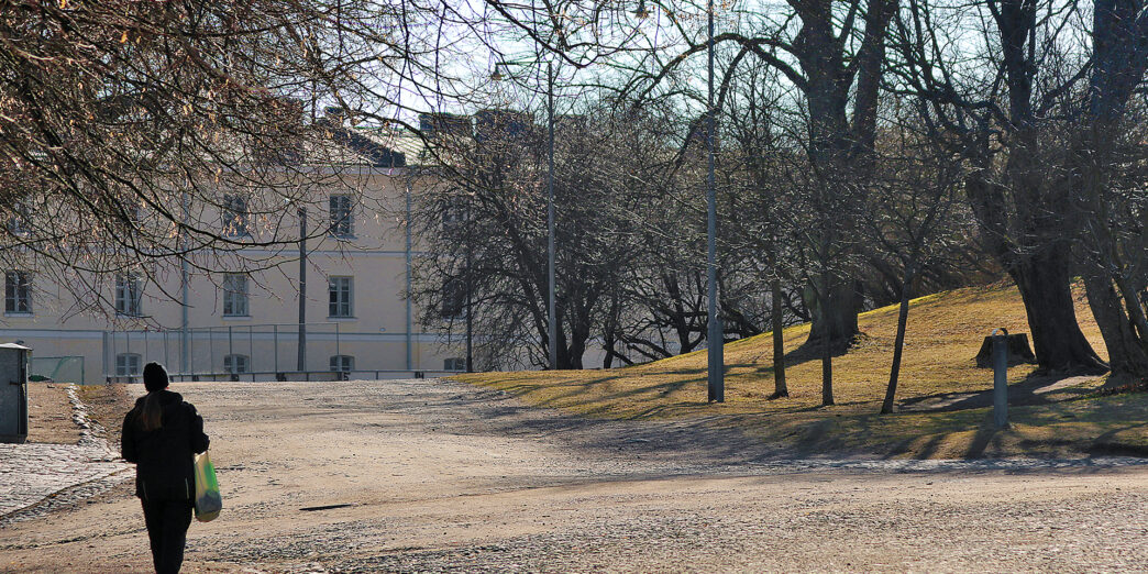 a person walking on a dirt road with a bag