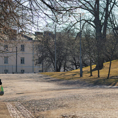 a person walking on a dirt road with a bag