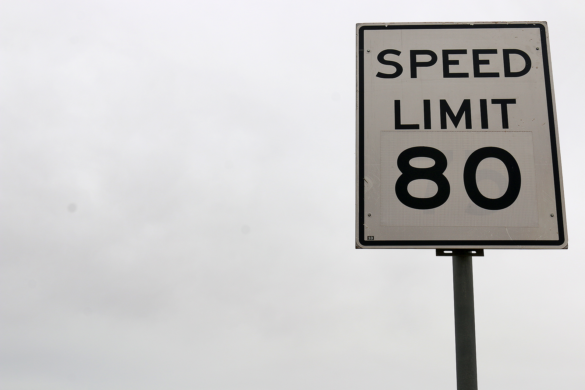 a speed limit sign on a pole