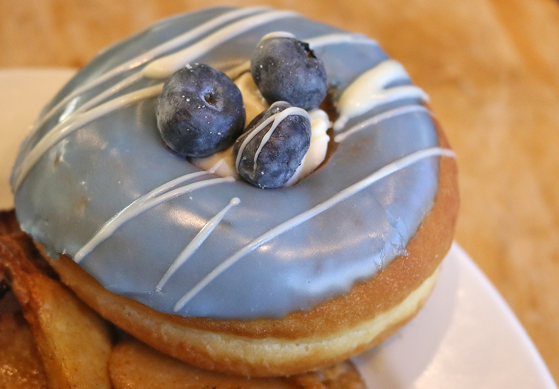 a donut with blue icing and blueberries