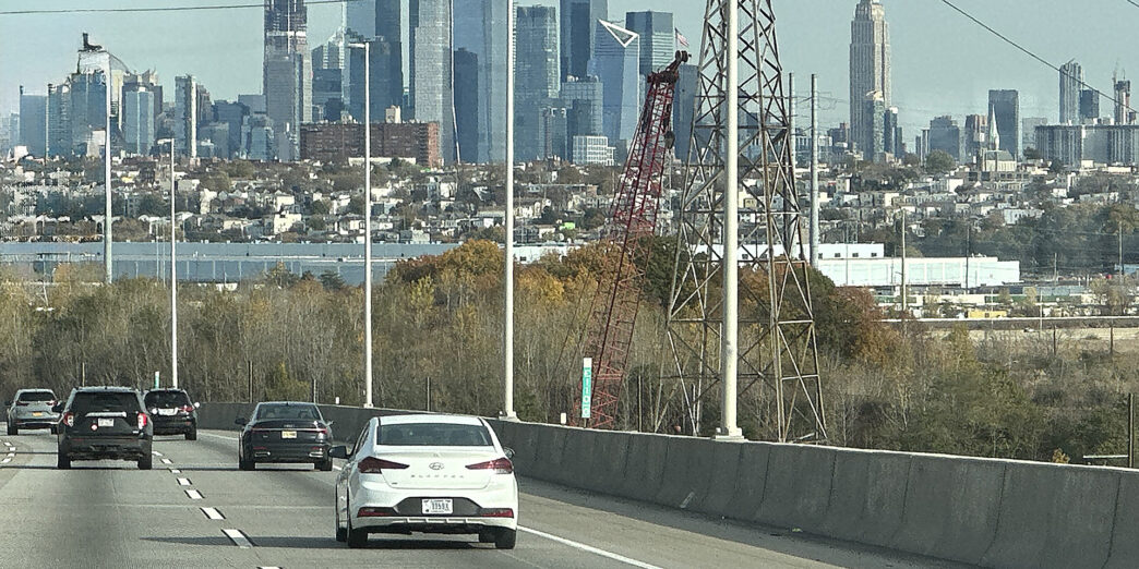 cars on a road with a city in the background