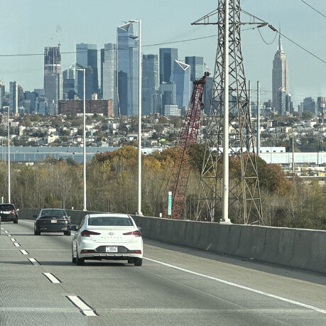 cars on a road with a city in the background