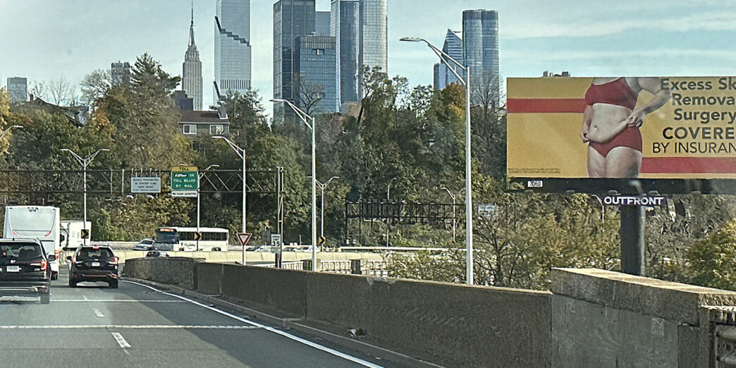 a road with a city skyline in the background
