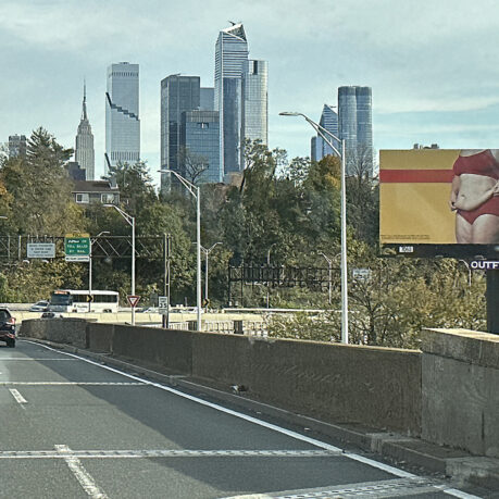 a road with a city skyline in the background