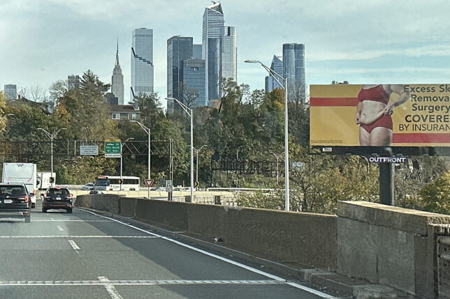a road with a city skyline in the background