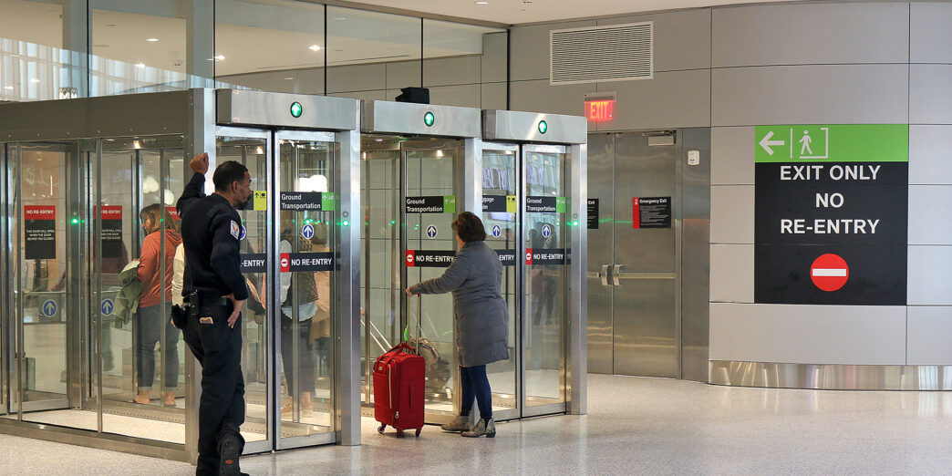 a group of people standing in front of glass doors