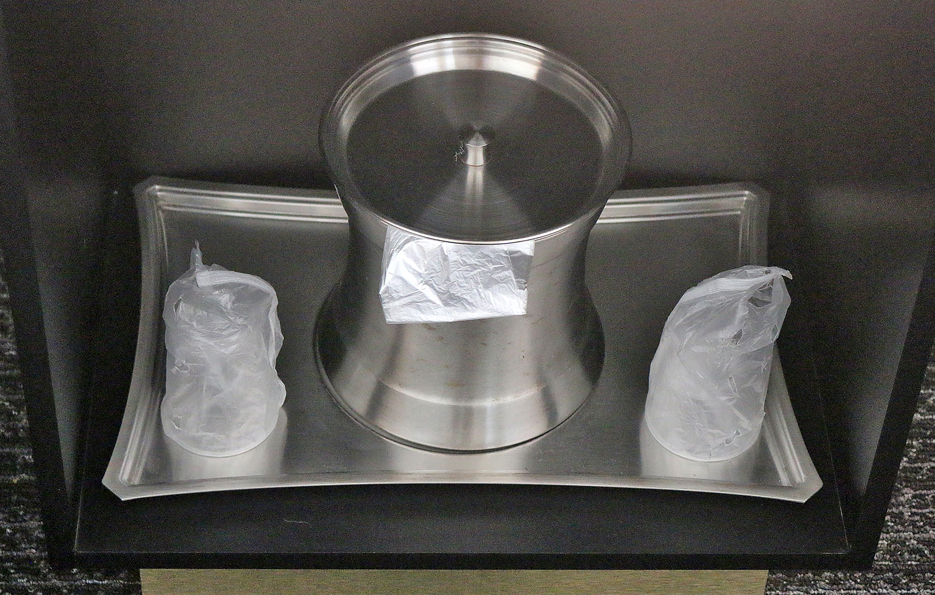 a silver container with plastic bags on a tray