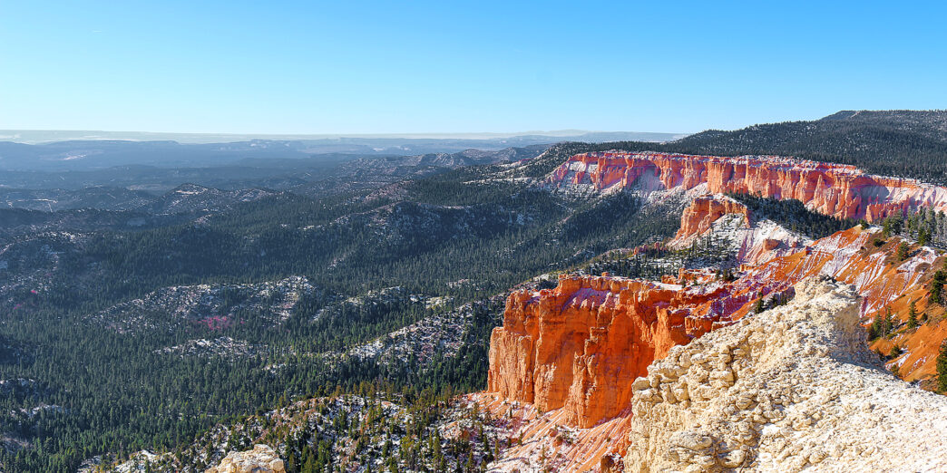 a red cliffs and trees in the distance