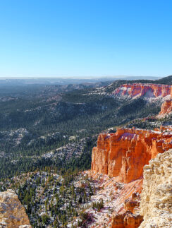 a red cliffs and trees in the distance