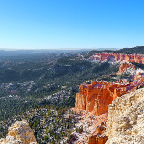 a red cliffs and trees in the distance