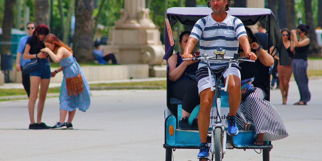 a man riding a bicycle with people in the back