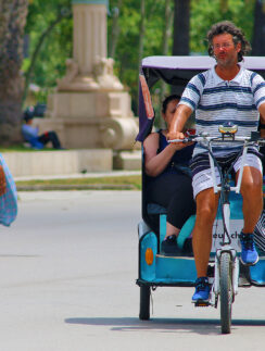 a man riding a bicycle with people in the back