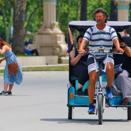 a man riding a bicycle with people in the back