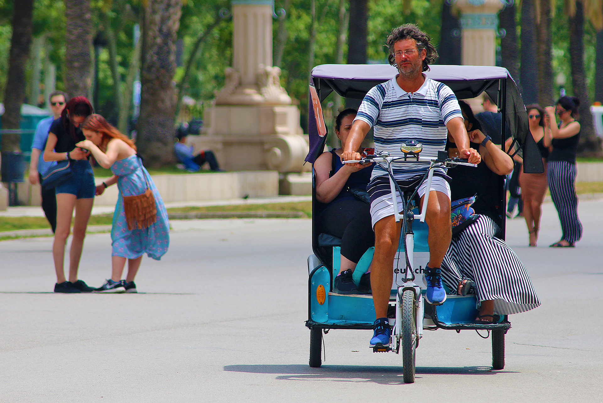 a man riding a bicycle with people in the back