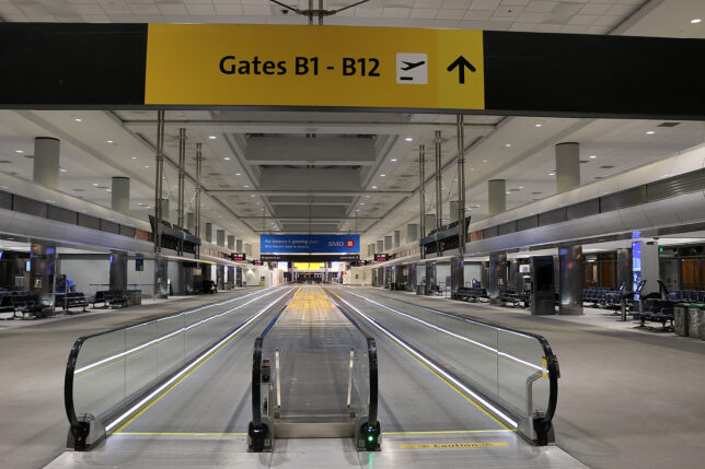 an empty airport with an escalator
