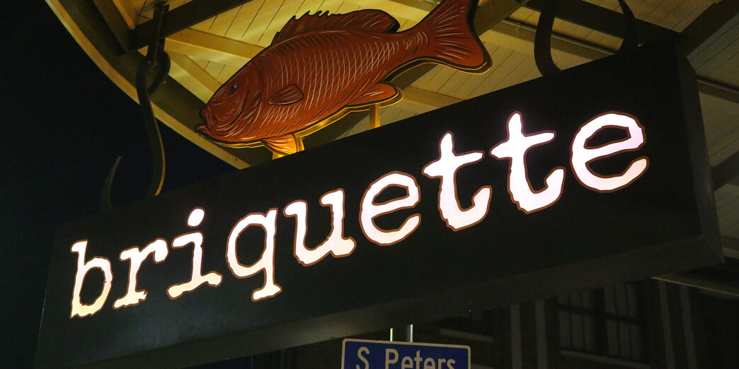 a sign with a fish and a street sign