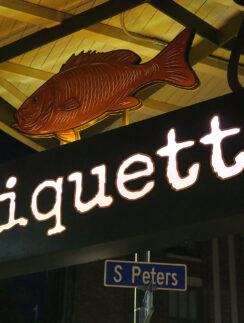 a sign with a fish and a street sign