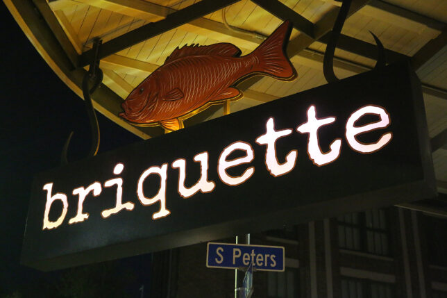 a sign with a fish and a street sign