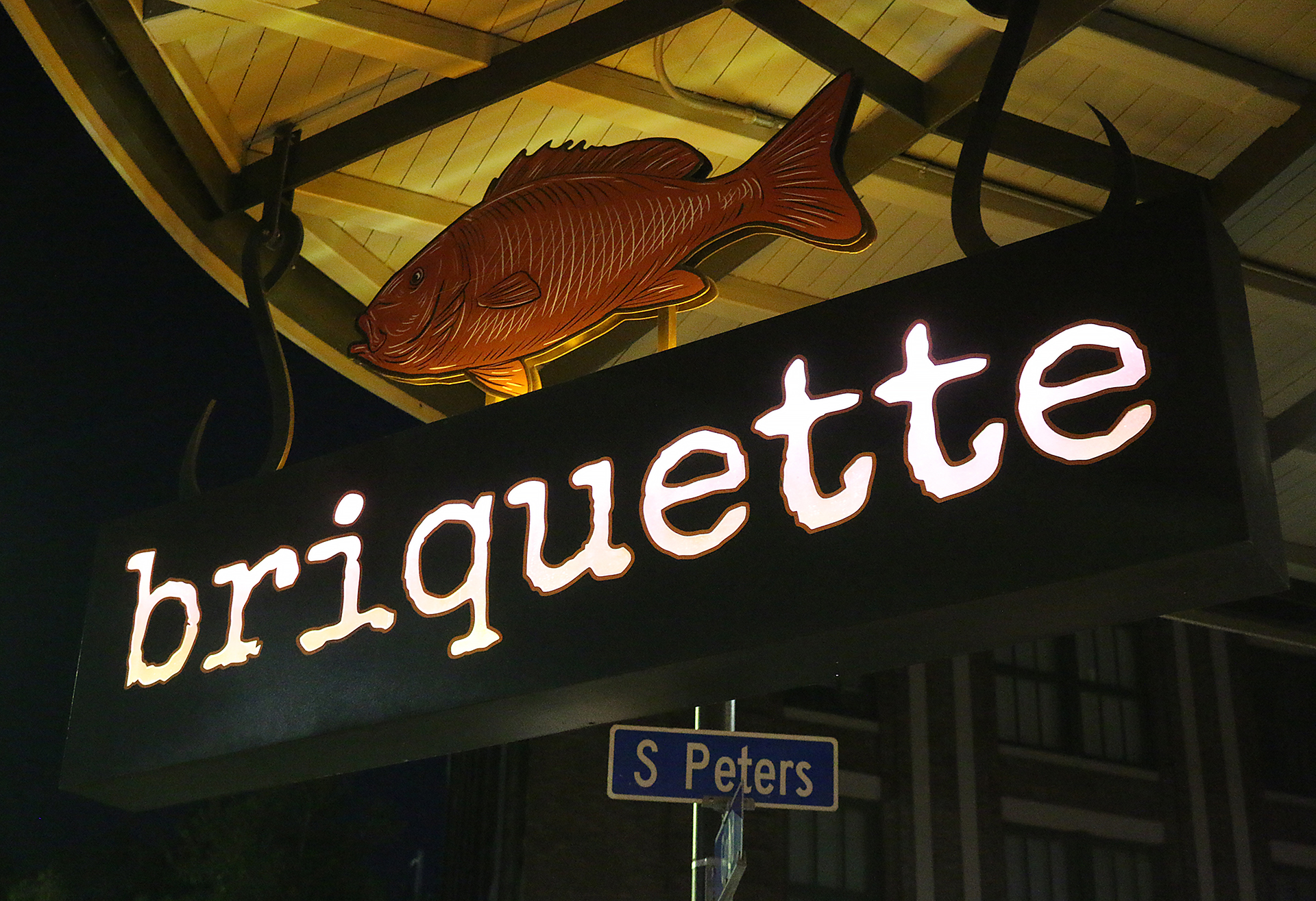 a sign with a fish and a street sign