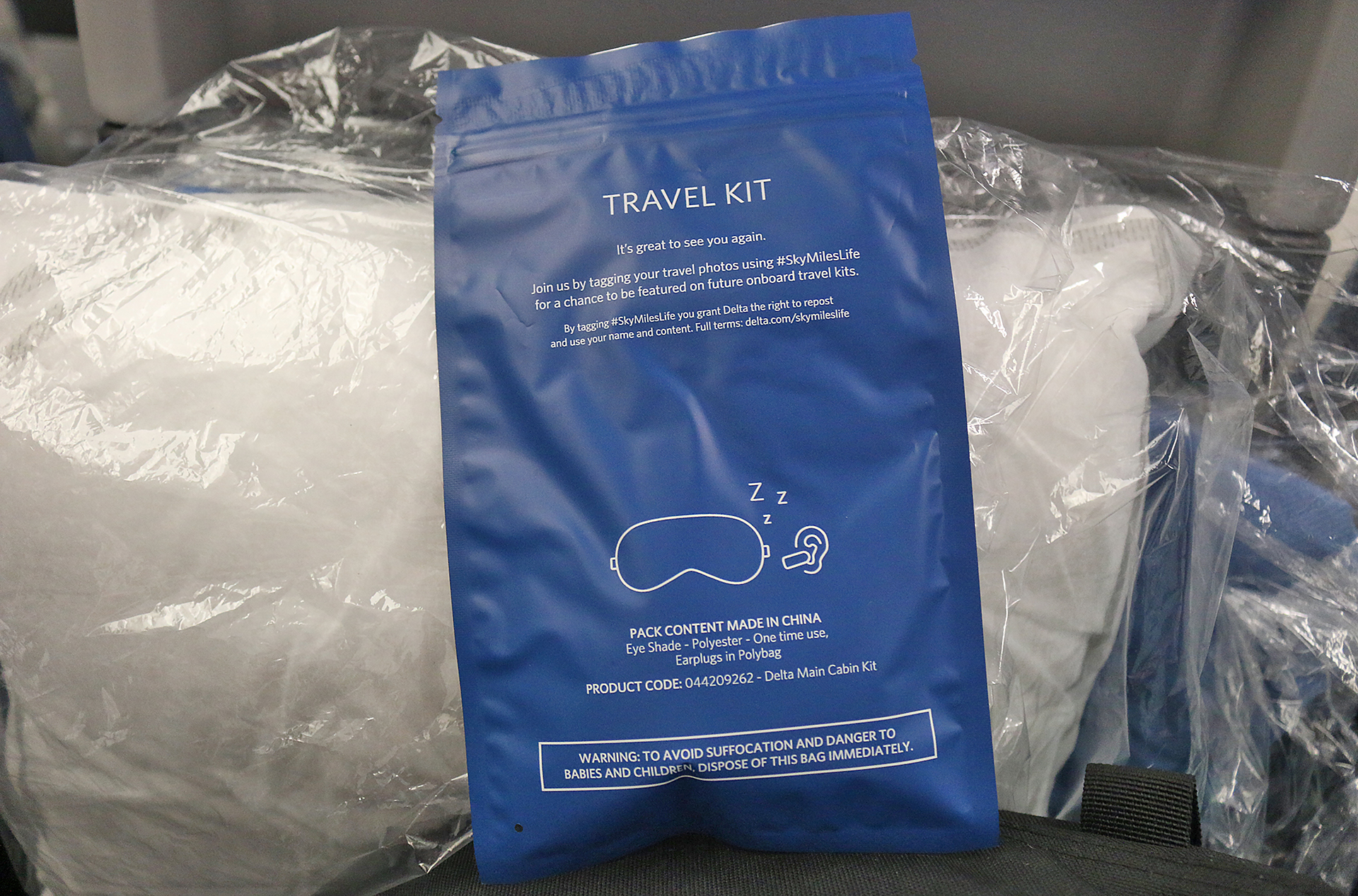 a blue bag with white text and a sleeping mask in it