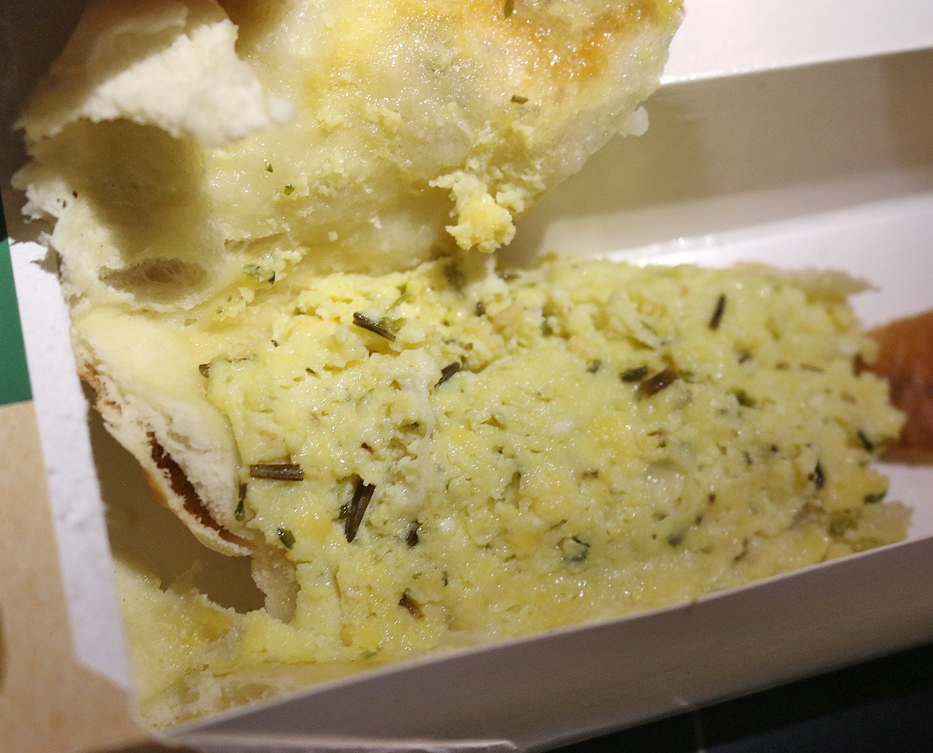 a piece of bread with cheese and herbs in a box
