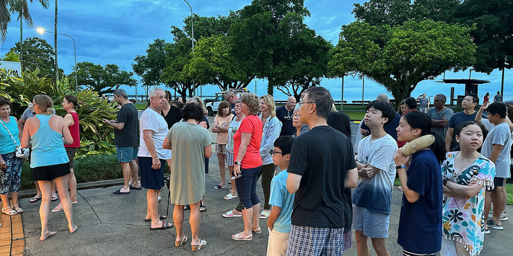 a group of people standing on a sidewalk
