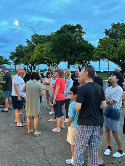 a group of people standing on a sidewalk