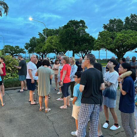 a group of people standing on a sidewalk