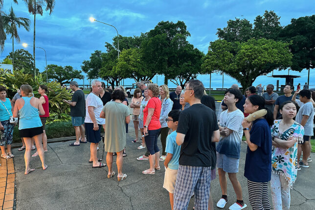 a group of people standing on a sidewalk