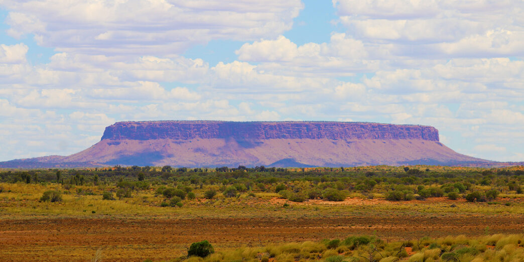 a landscape with a large hill in the distance
