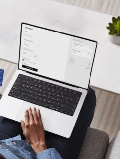 a person sitting on a couch using a laptop
