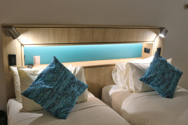 two beds with pillows on each other