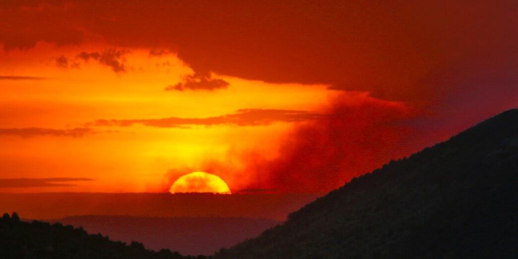 a sunset over a mountain