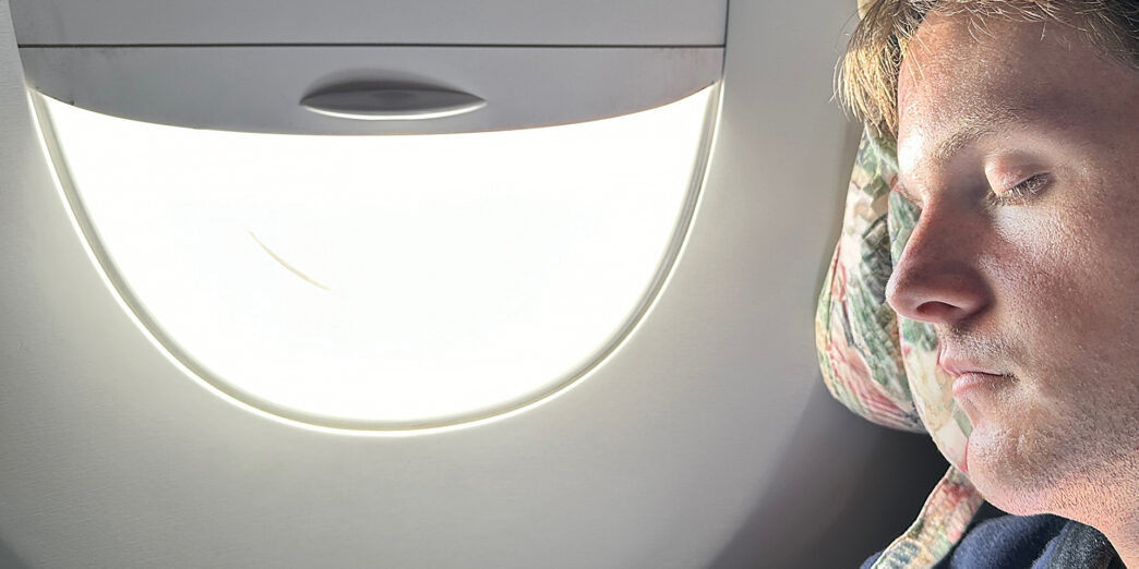 a person sitting in an airplane with a light in the window