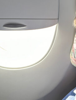 a person sitting in an airplane with a light in the window