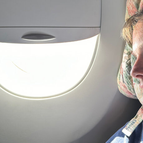 a person sitting in an airplane with a light in the window
