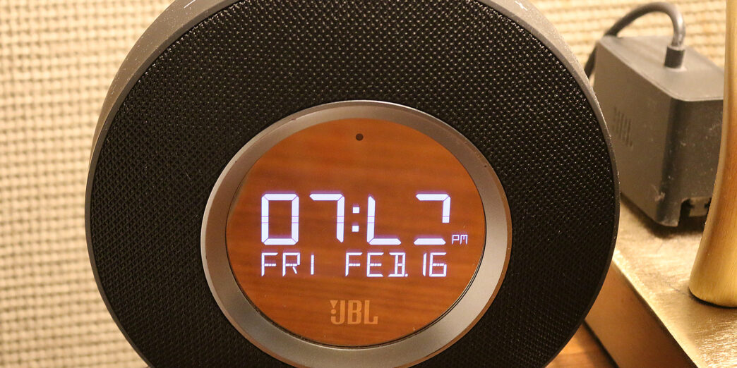 a round black alarm clock with a digital display