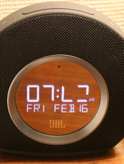 a round black alarm clock with a digital display