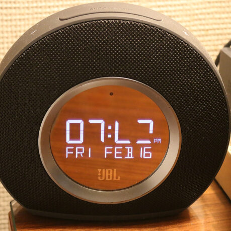 a round black alarm clock with a digital display