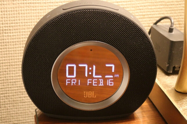 a round black alarm clock with a digital display