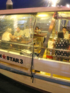 a group of people sitting at a table in a boat