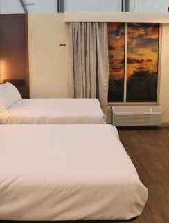 a room with two beds and a window