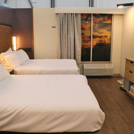 a room with two beds and a window