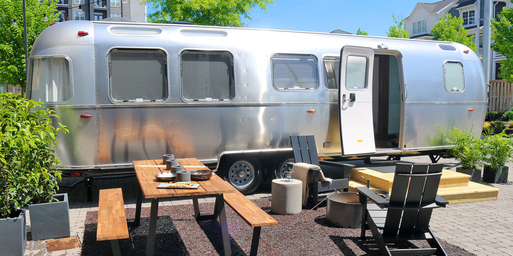 a silver trailer with chairs and tables