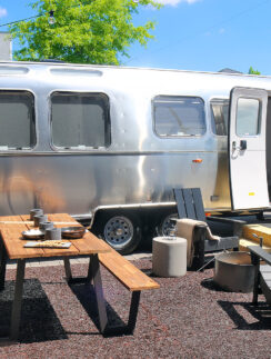 a silver trailer with chairs and tables