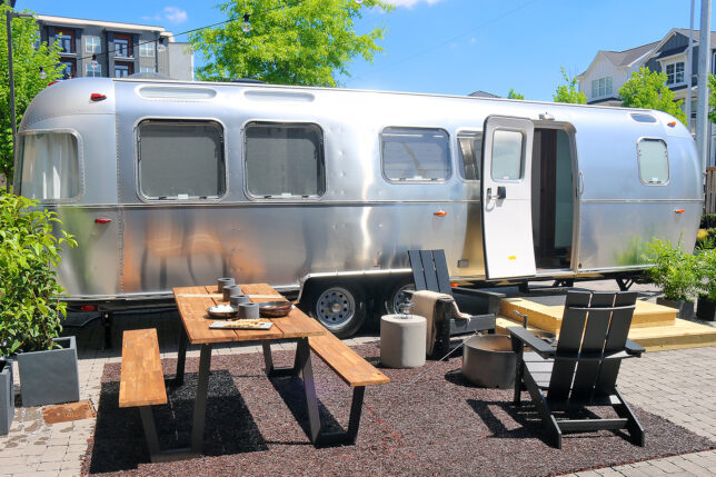 a silver trailer with chairs and tables