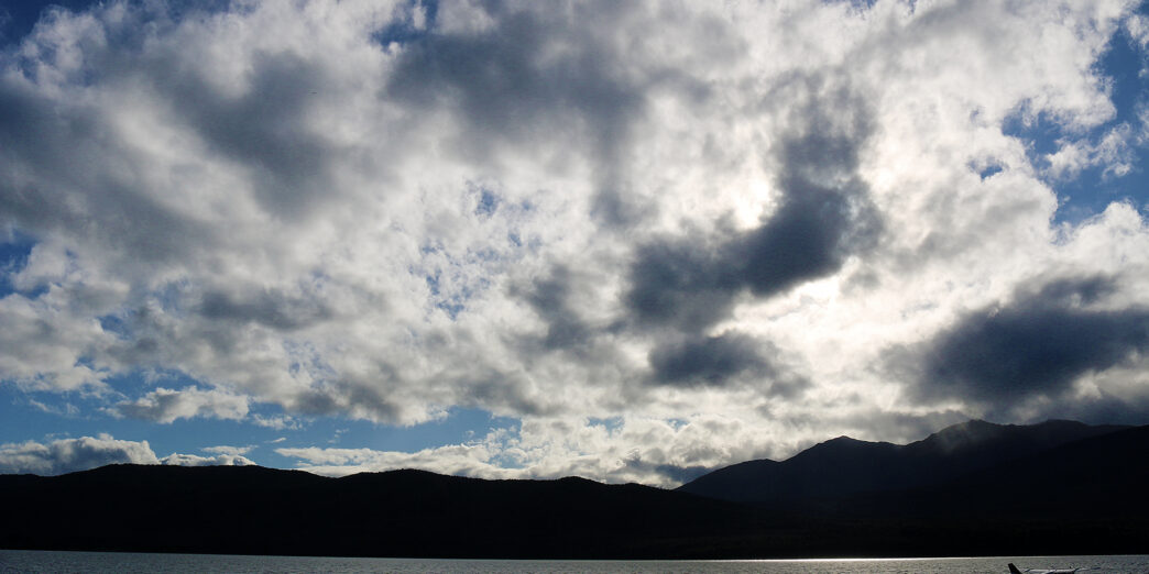 a body of water with mountains in the background