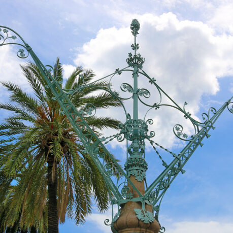 a metal pole with a palm tree in the background